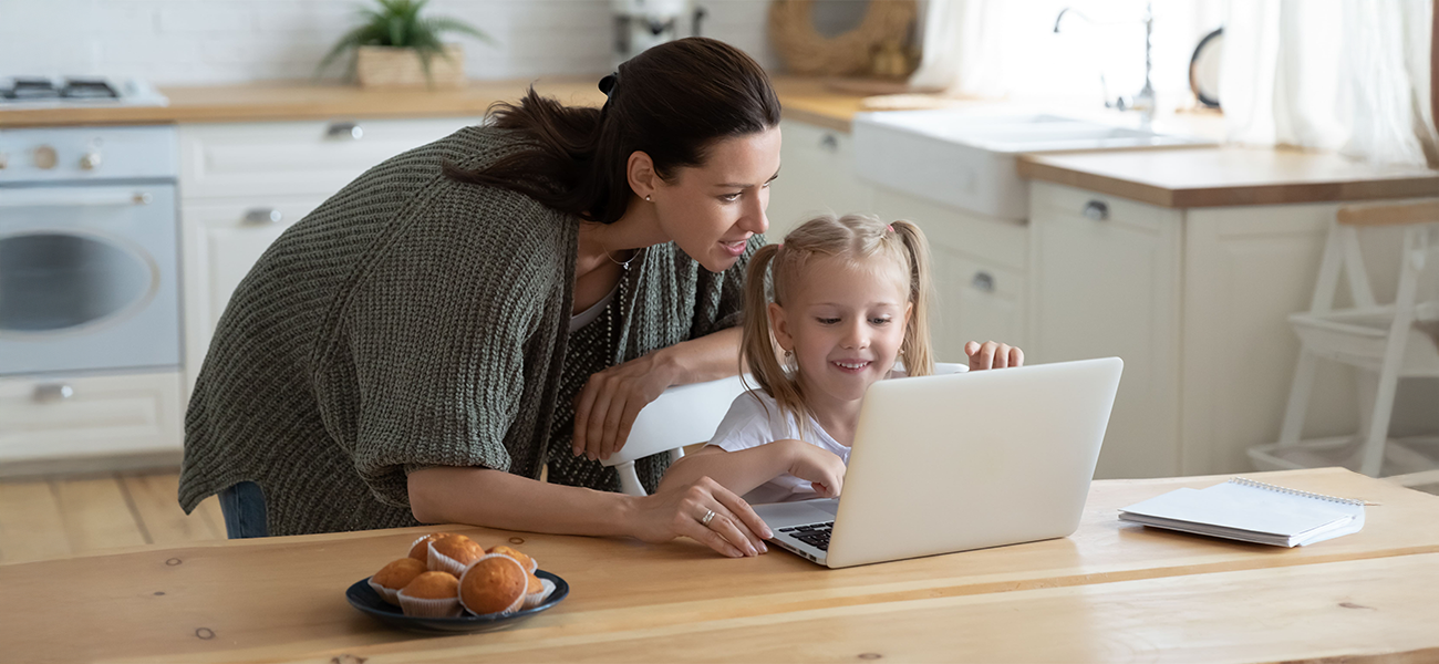 A mother helping her child on the computer at home.