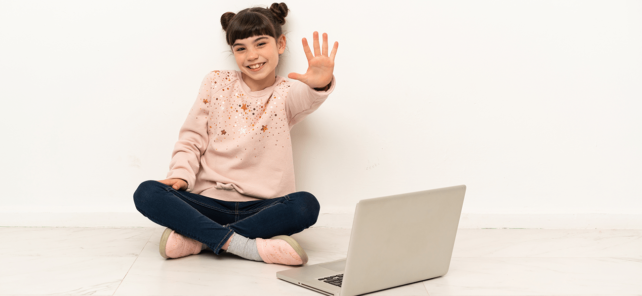 School girl with laptop holding up five fingers.
