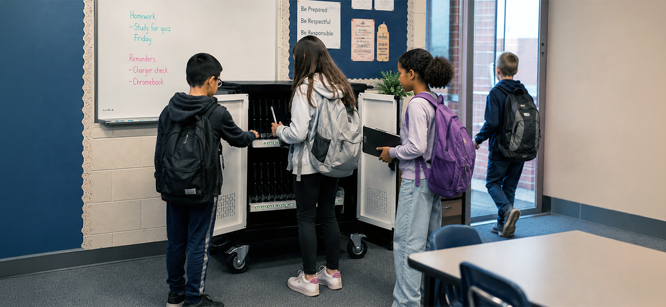 Image: Students grabbing chromebooks from a charging cart before leaving for the day.